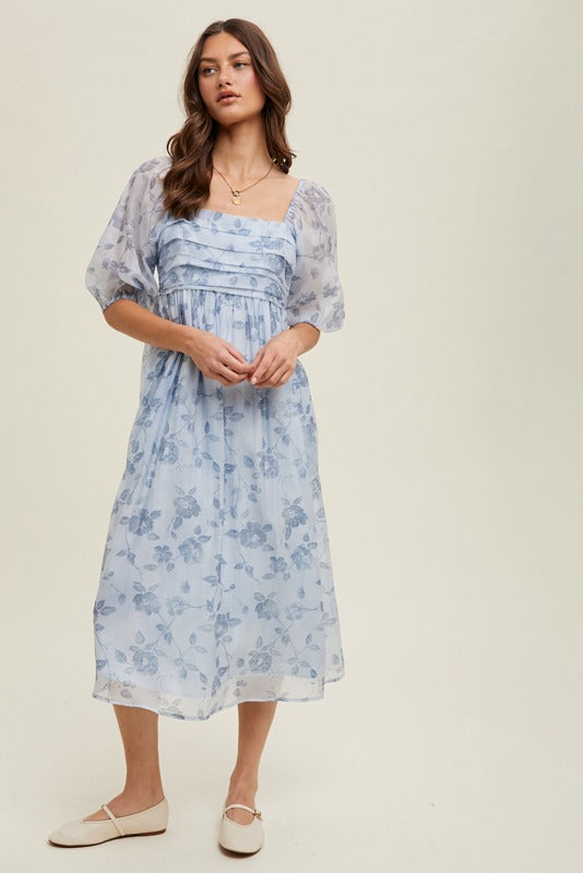 Woman wearing a light blue floral dress on a beige background