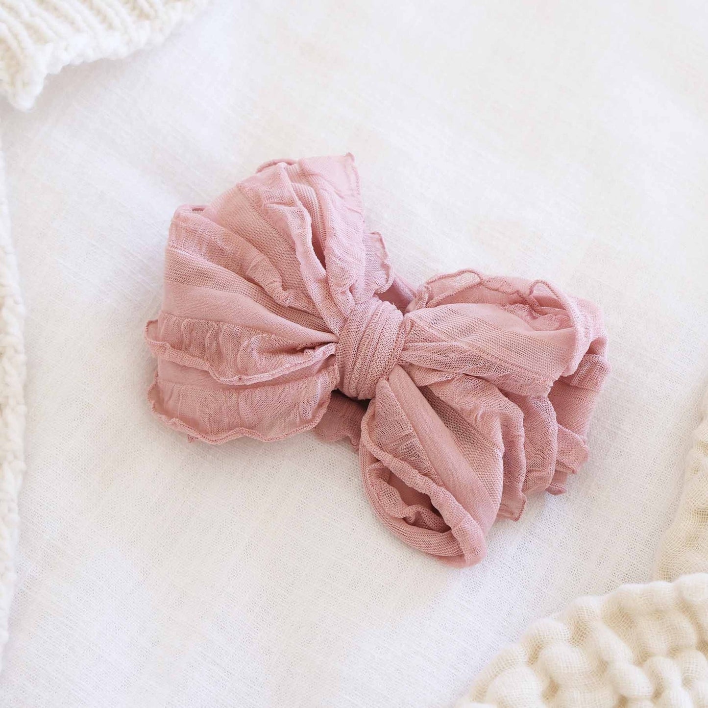 Pink scrunchie on a white pillow