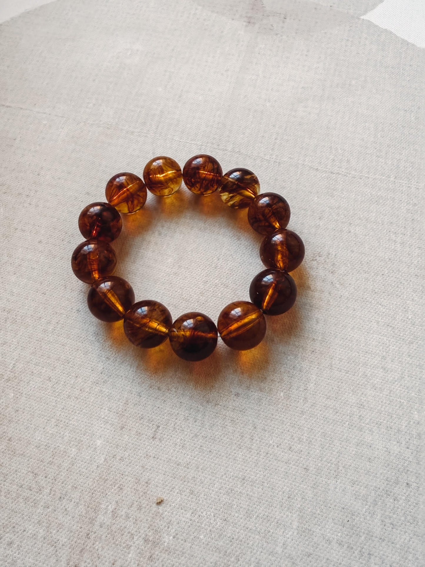 Brown beaded bracelet on a light gray fabric background