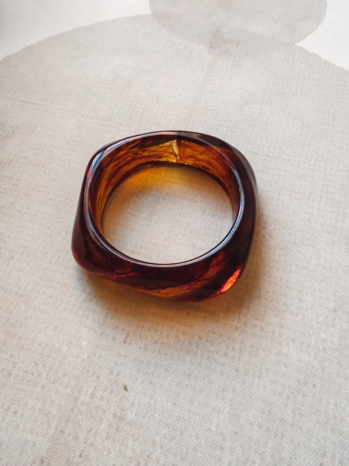 Brown tortoiseshell ring on a light fabric background