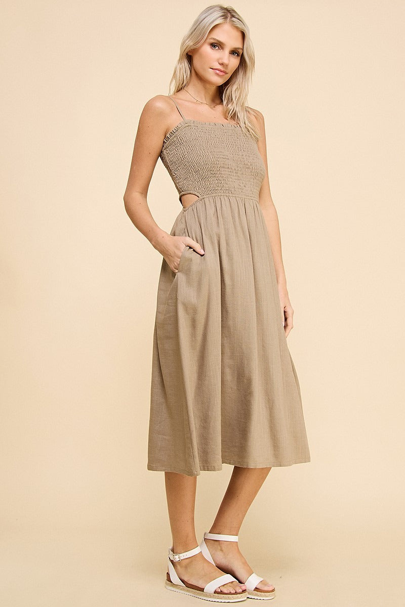 Woman wearing a beige dress with cut-out design on a beige background