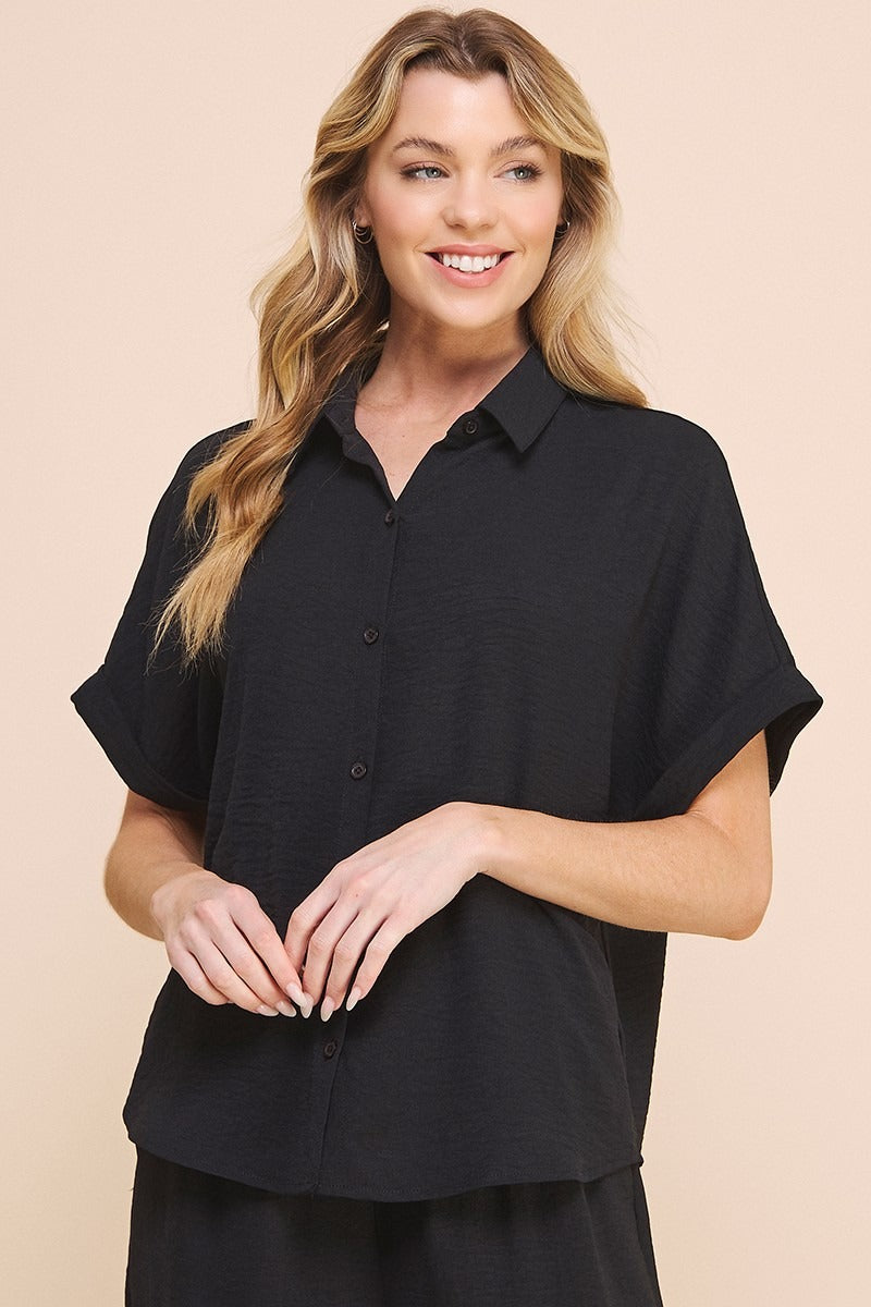Woman wearing a black shirt against a beige background