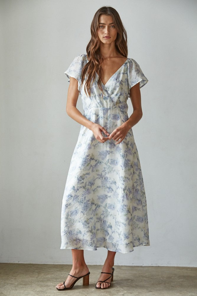 Woman wearing a floral dress against a plain background