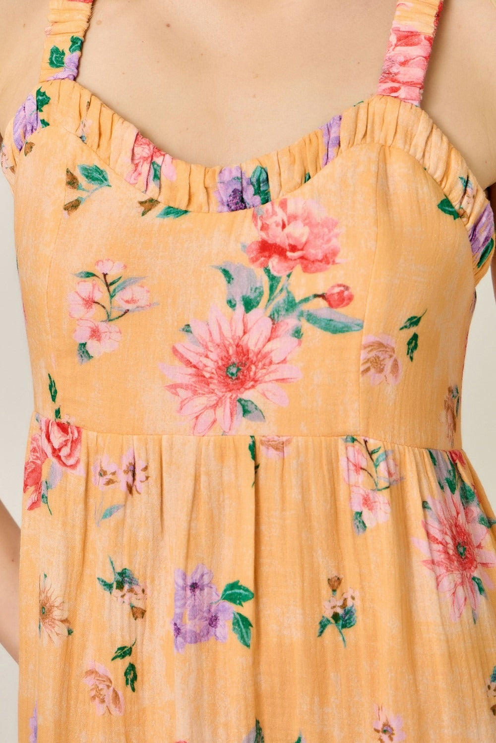 Yellow floral dress with pink and purple flowers on a plain background