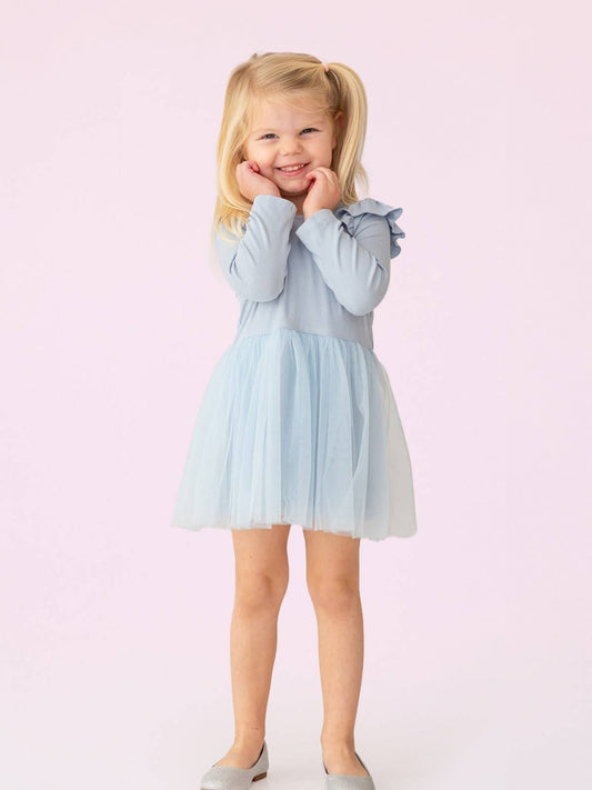 Young girl wearing a light blue dress against a pink background