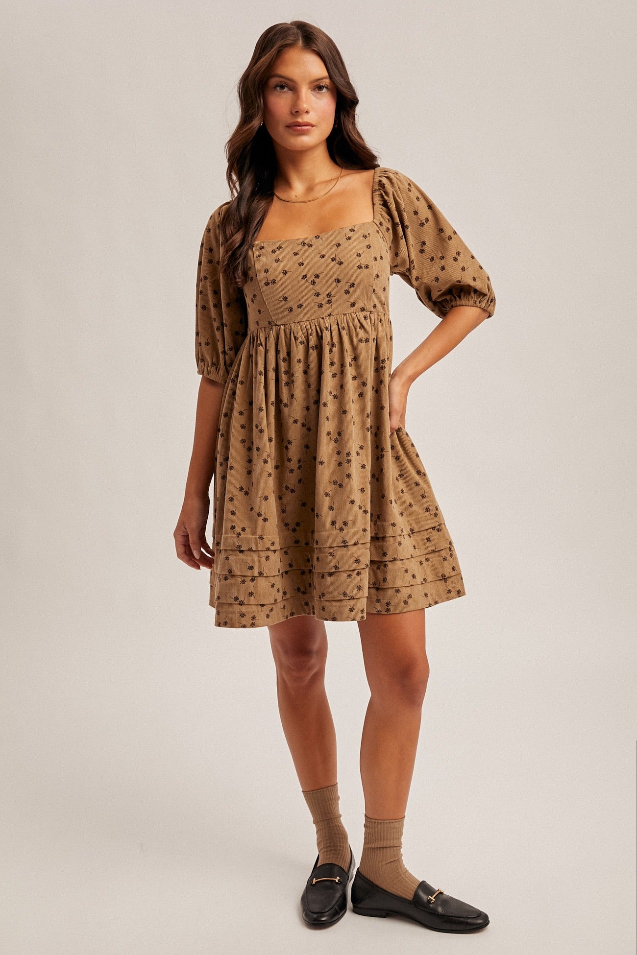 Woman wearing a patterned dress on a plain background