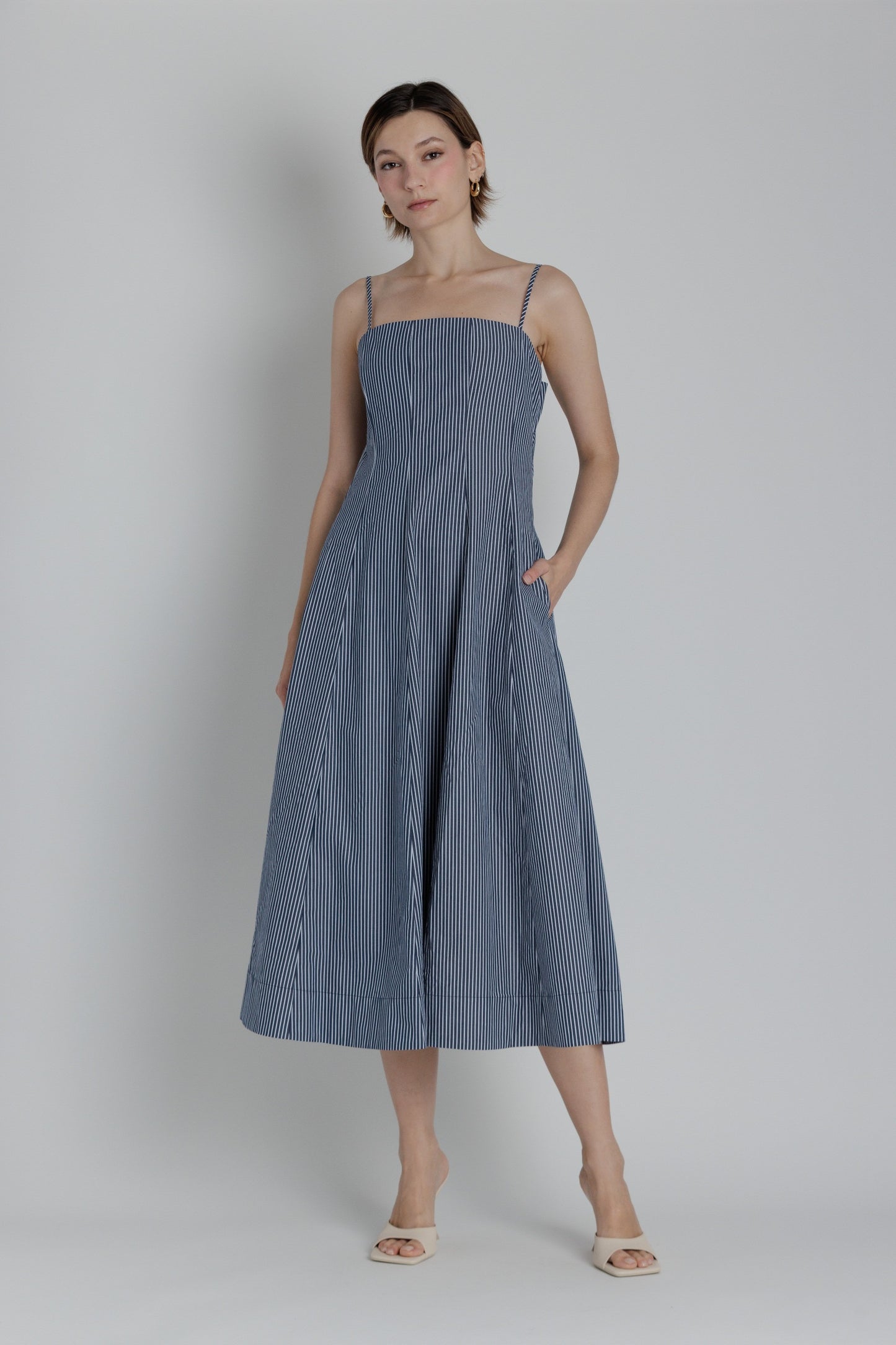 Woman wearing a blue dress against a plain background