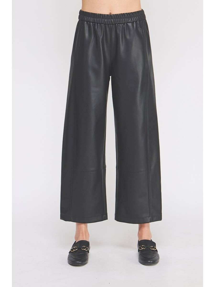 Black leather wide-leg pants worn by a person on a white background