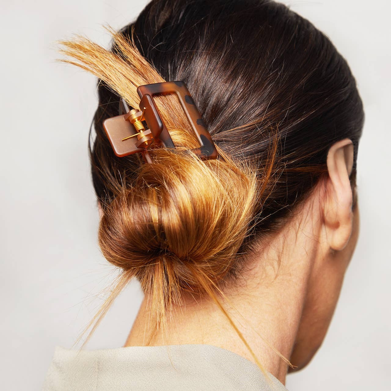 Close-up of a hair clip in a person's hair with a plain background