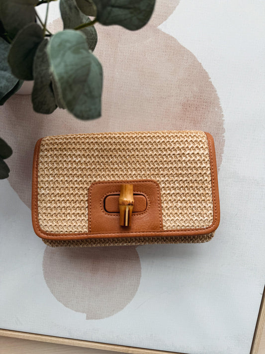 Woven handbag with brown leather accents on a light background