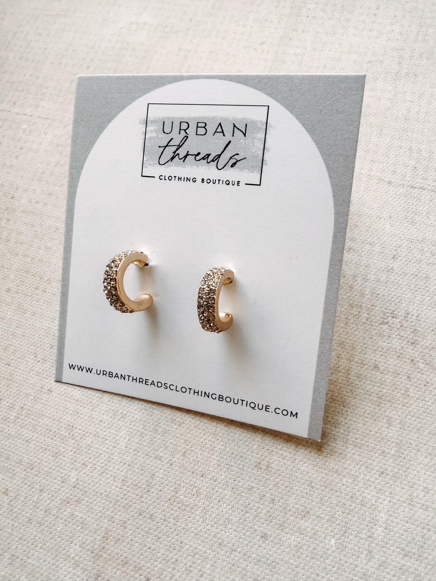 Gold hoop earrings on a card from Urban Threads Clothing Boutique.