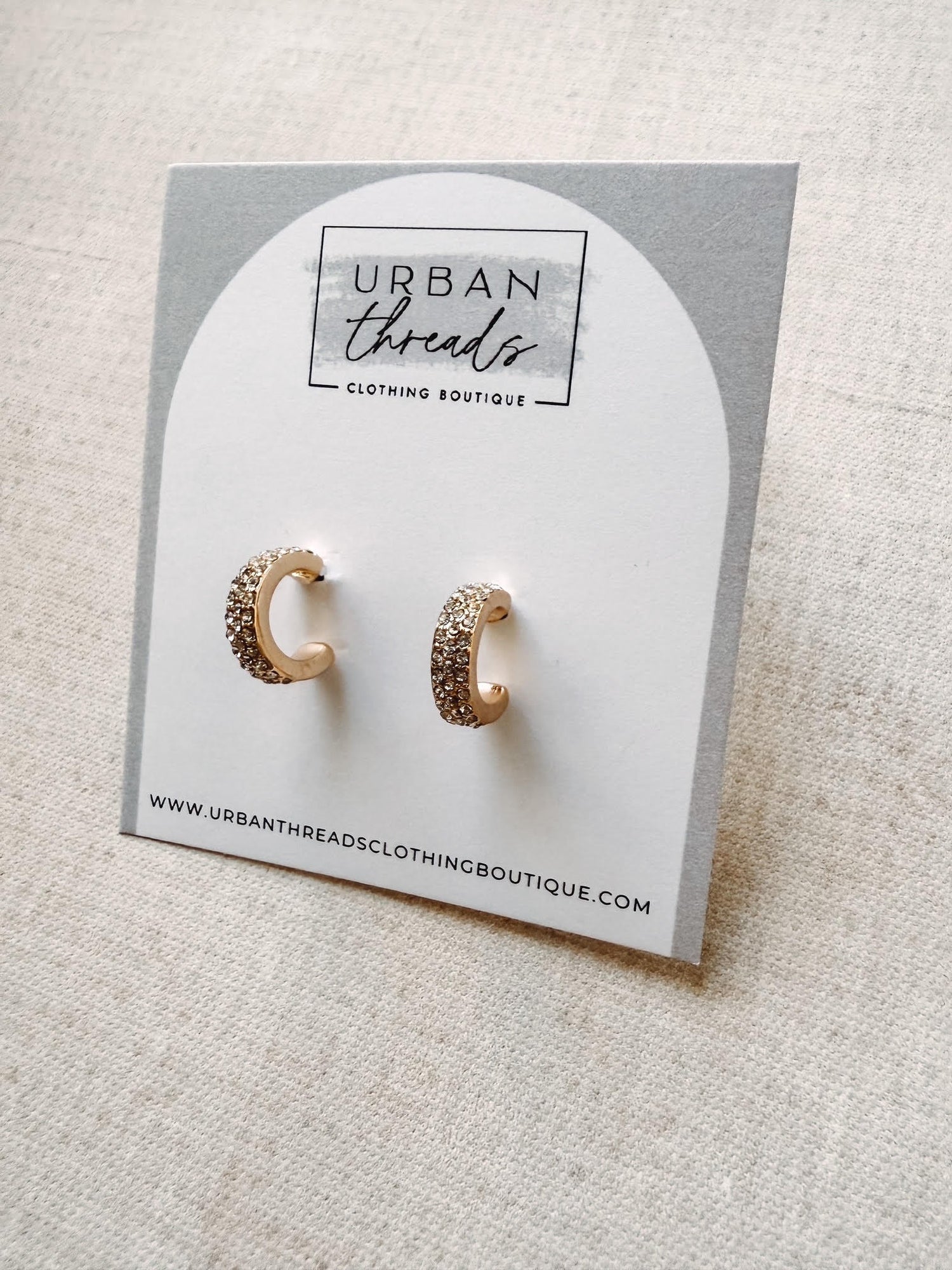 Gold hoop earrings on a card from Urban Threads Clothing Boutique.