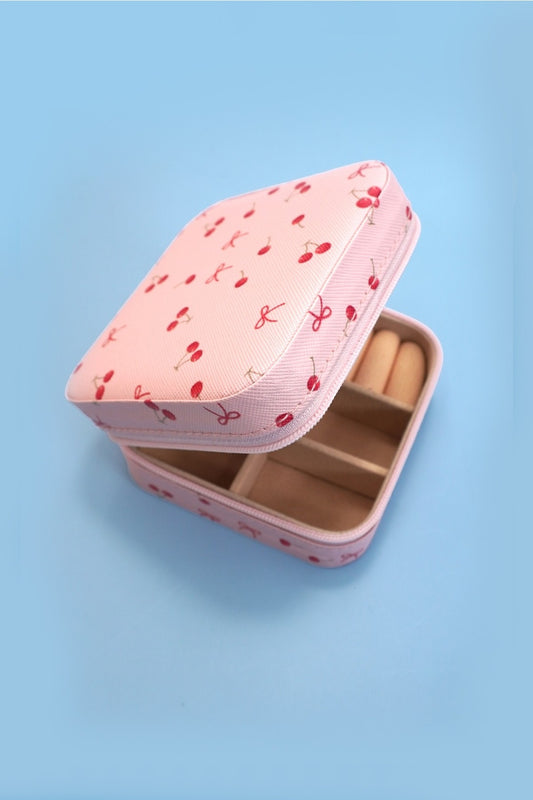 Pink bento box with cherry pattern on a light blue background