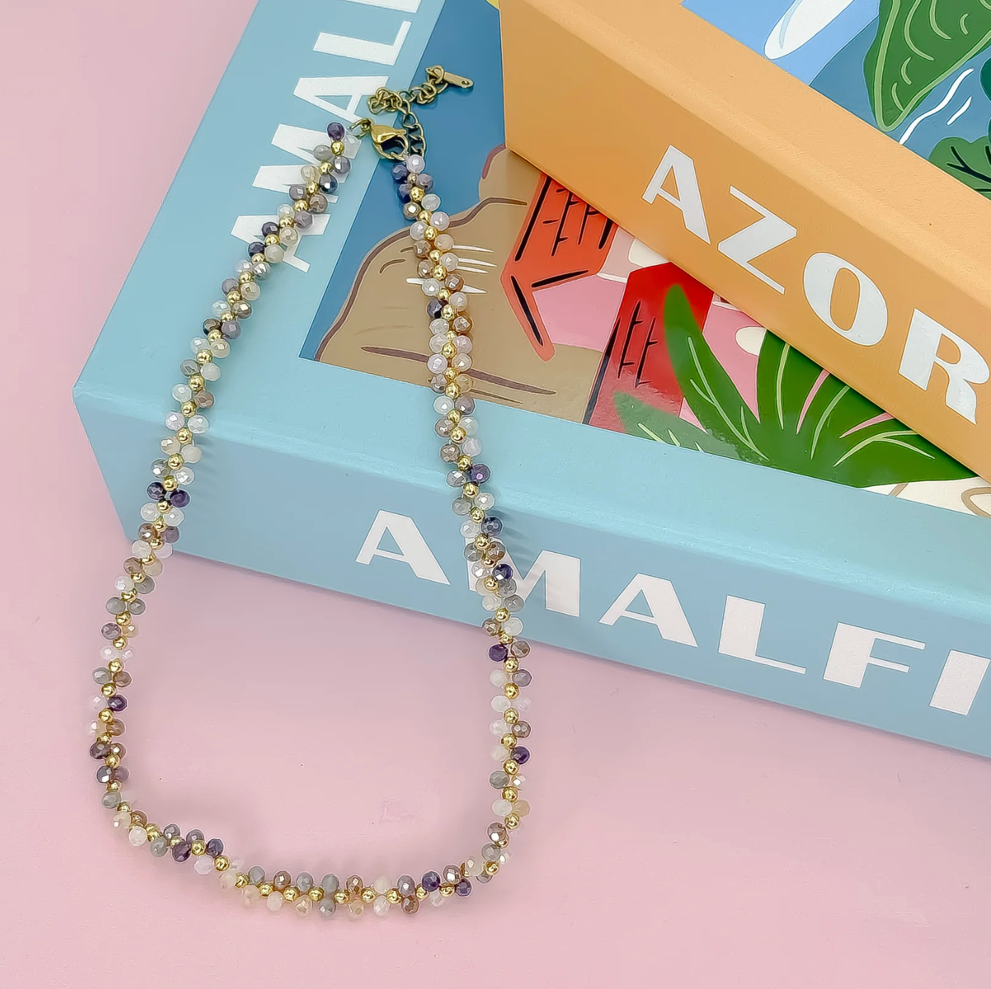 Beaded necklace on a book with 'Amalfi' and 'Azores' text