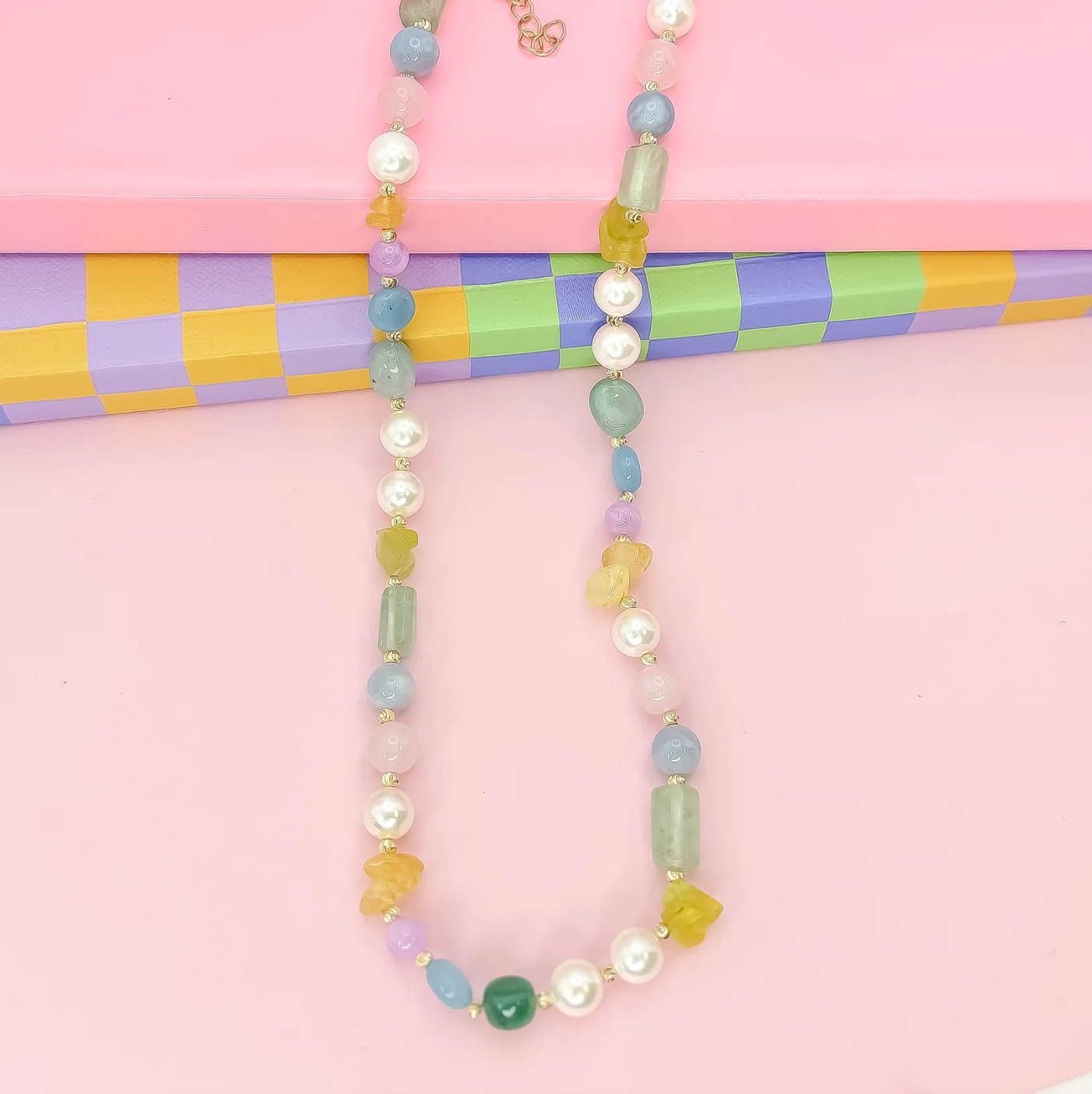 Necklace with pastel beads on a pink background