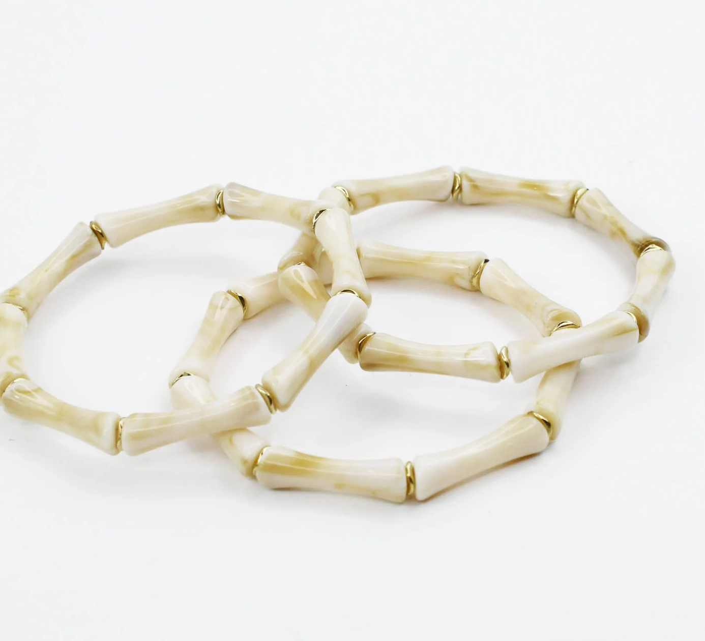 Set of three bone-like bracelets on a white background