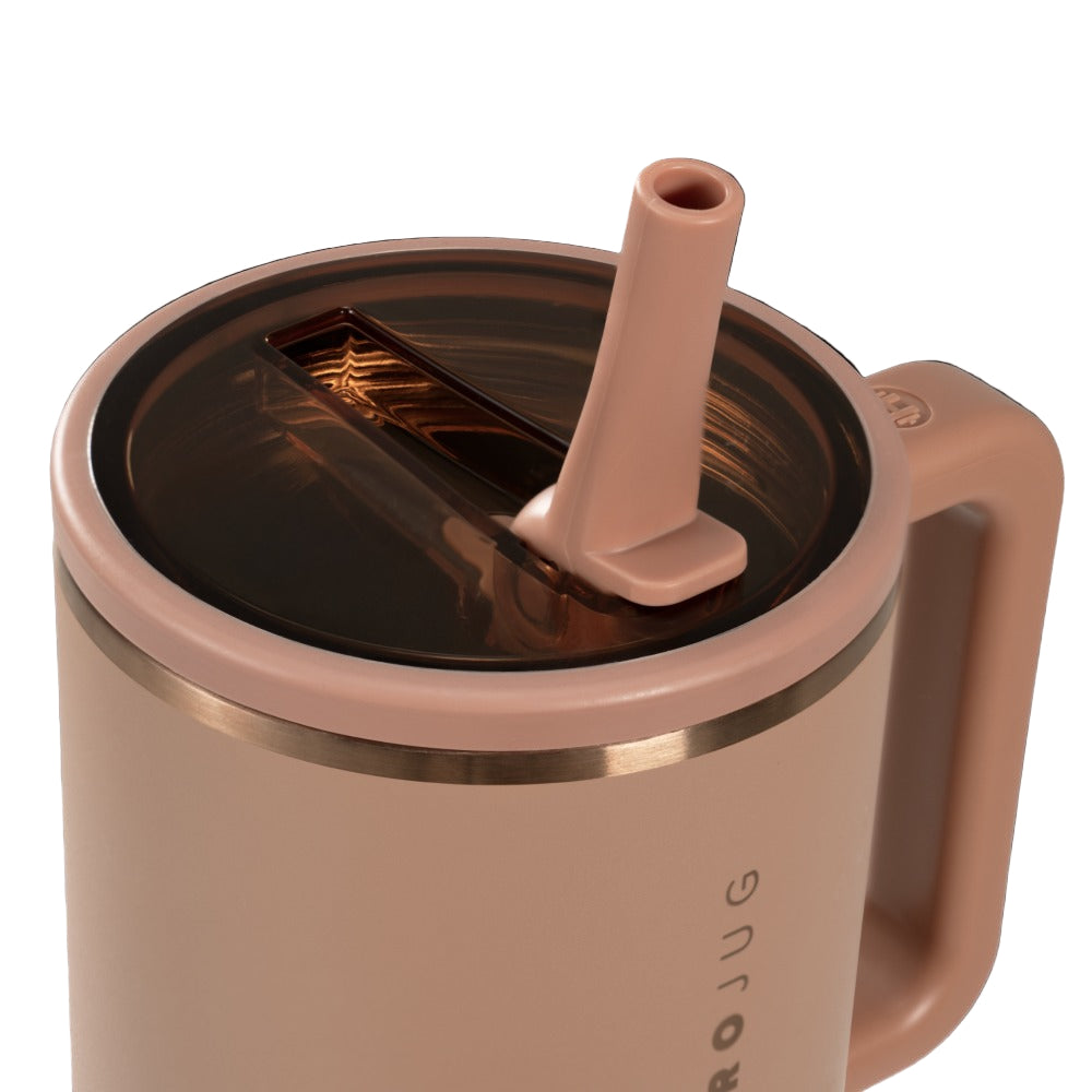 Rose gold mug with straw lid on a white background