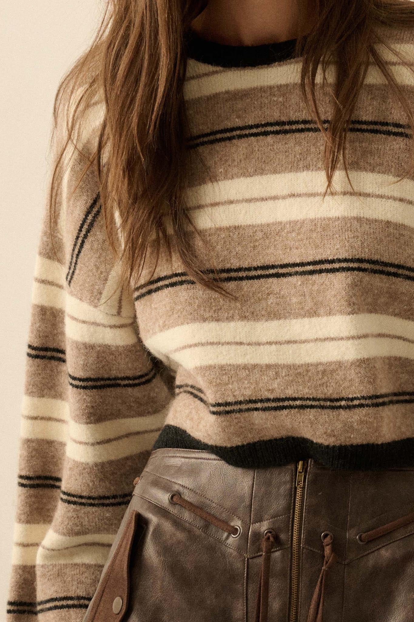Close-up of a person wearing a striped sweater with a neutral background
