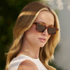Woman wearing sunglasses with a blurred natural background