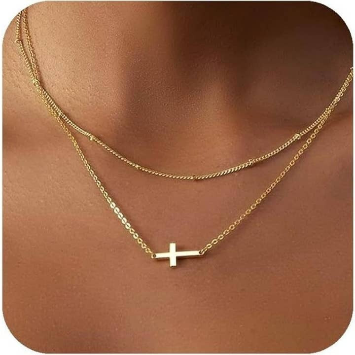Gold necklace with a cross pendant on a person's neck