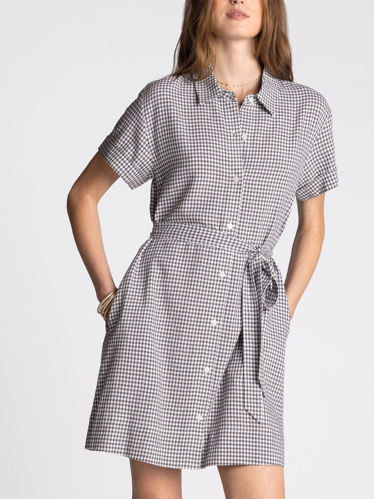 Woman wearing a black and white checkered dress on a plain background