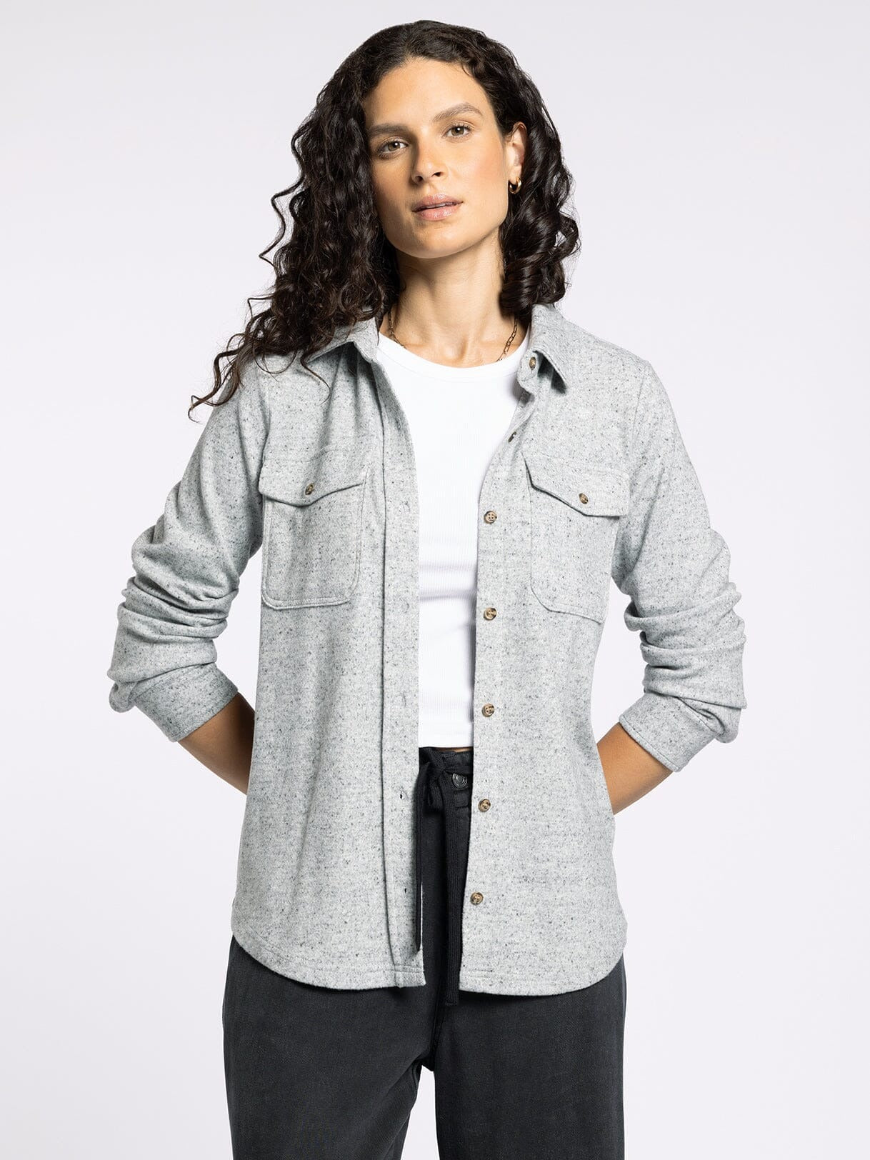 Person wearing a gray flannel shirt over a white t-shirt on a white background
