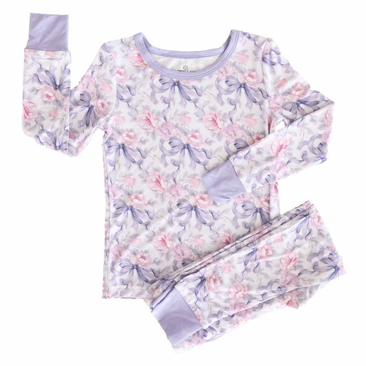 Children's pajama set with floral and bow pattern on a white background