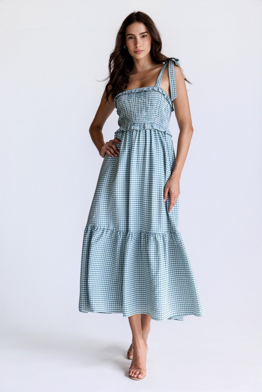 Woman wearing a blue checkered dress on a white background