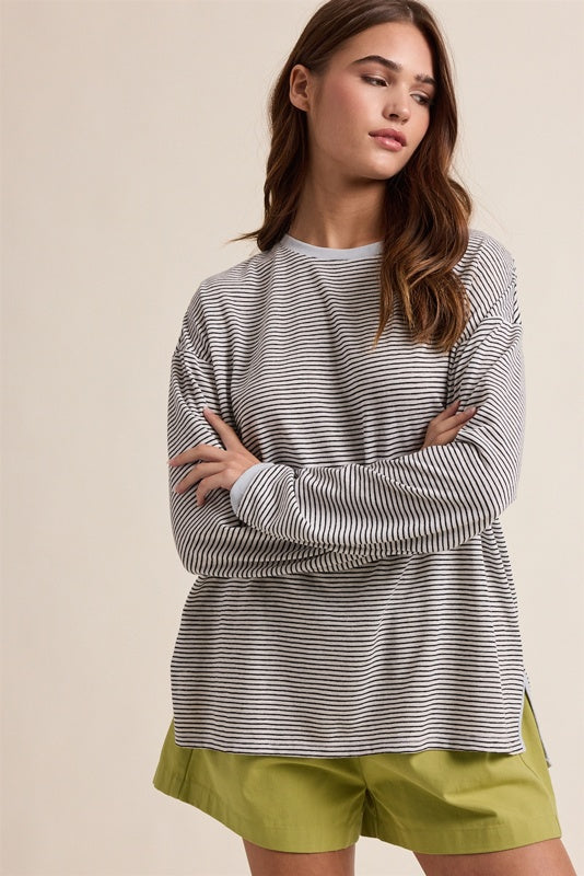 Woman wearing a striped long-sleeve top and green shorts on a beige background