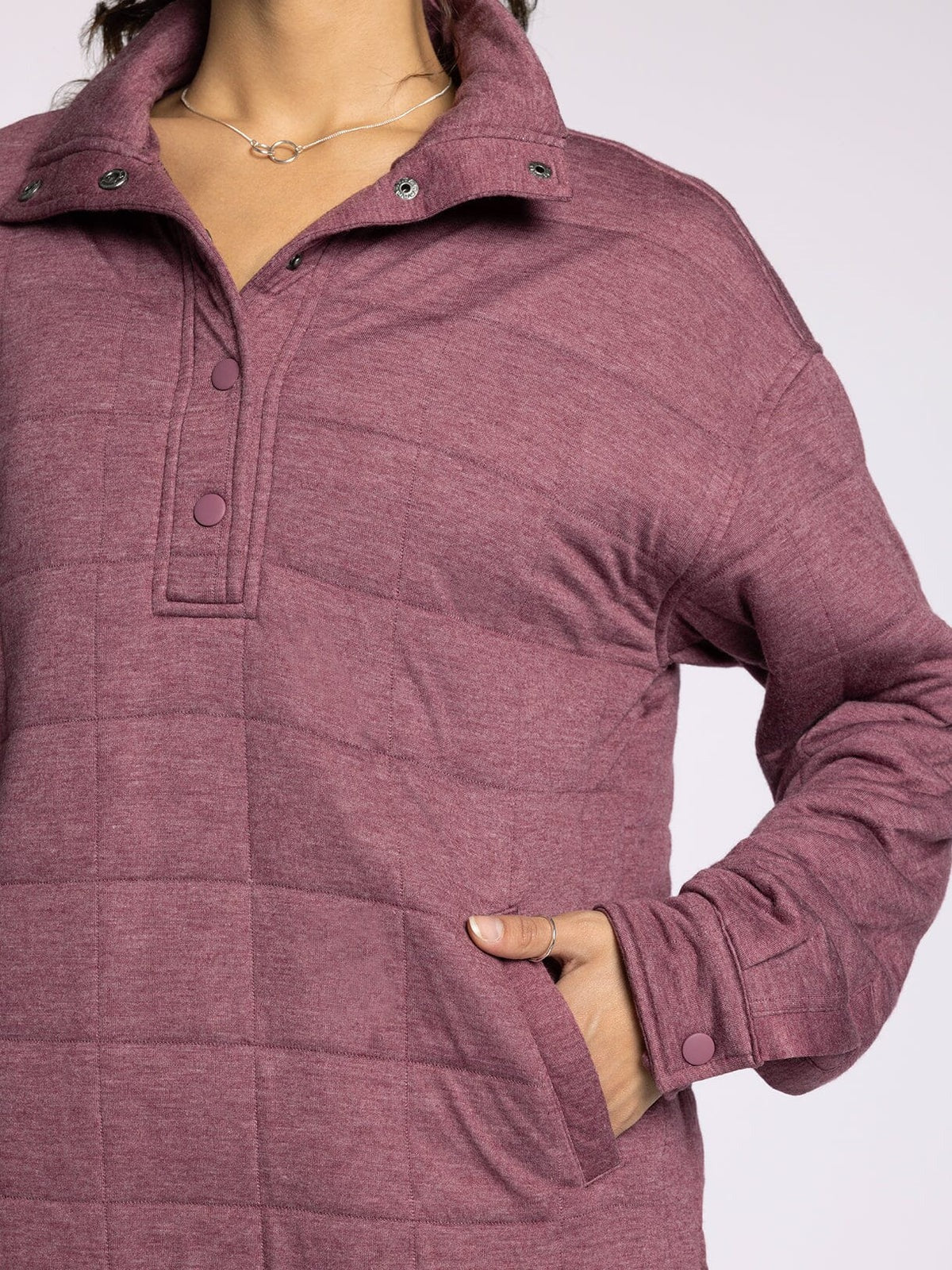 Close-up of a maroon quilted jacket on a white background