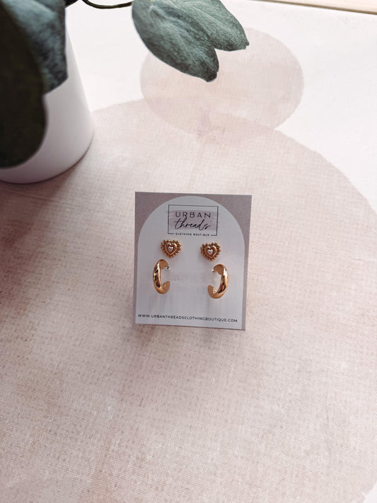 Gold earrings on a card with 'Urban Threads' branding on a light fabric background