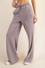 Person wearing light purple sweatpants on a beige background