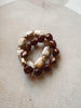 Beaded bracelet with brown and white beads on a beige fabric background