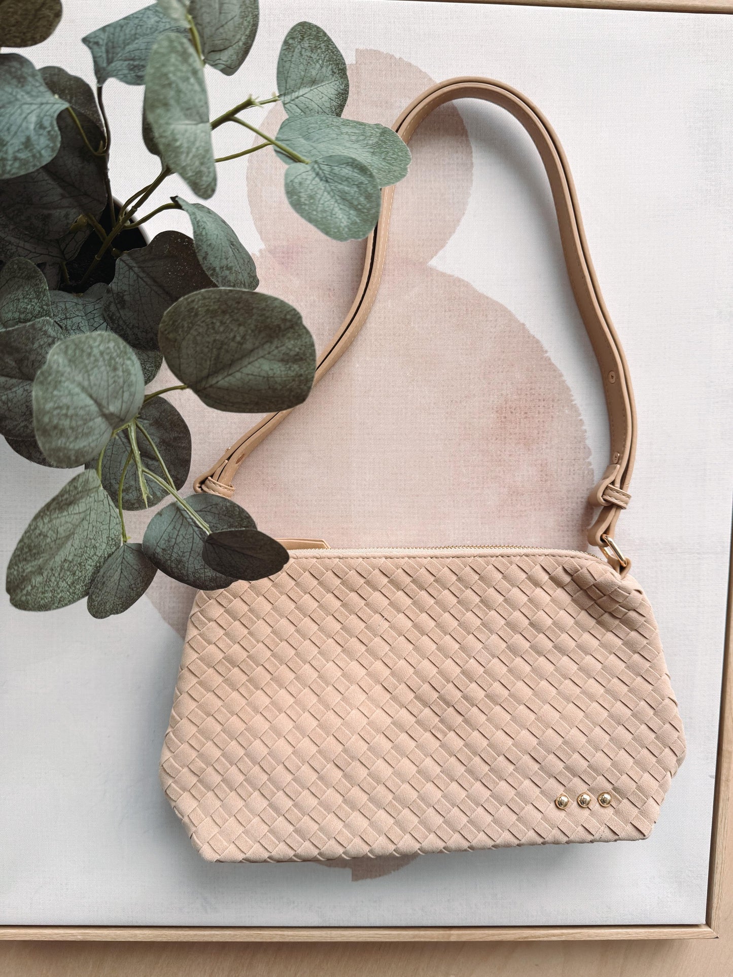 Beige handbag with textured pattern on a light background
