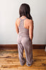 Person wearing a matching tank top and pants set on a wooden floor.