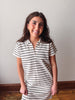 Woman wearing a black and white striped dress against a plain background