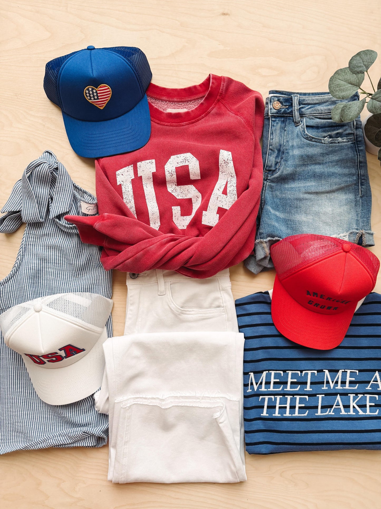 Collection of casual clothing and accessories on a wooden surface