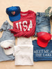 Collection of casual clothing and accessories on a wooden surface