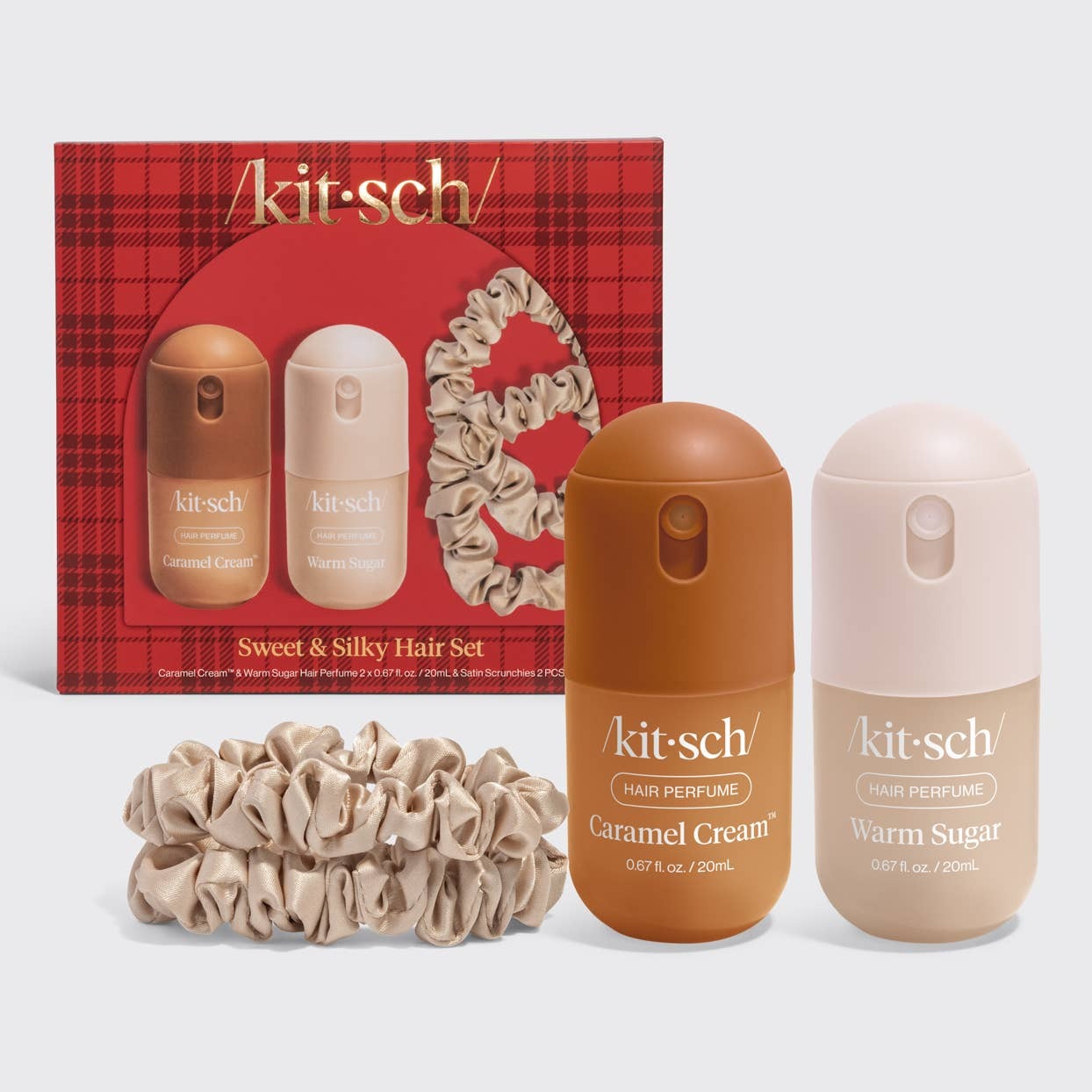 Kit-Sch Sweet & Silky Hair Set featuring a red plaid gift box, two hair perfume bottles (Caramel Cream and Warm Sugar), and two matching satin scrunchies on a light gray background.