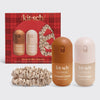 Kit-Sch Sweet & Silky Hair Set featuring a red plaid gift box, two hair perfume bottles (Caramel Cream and Warm Sugar), and two matching satin scrunchies on a light gray background.