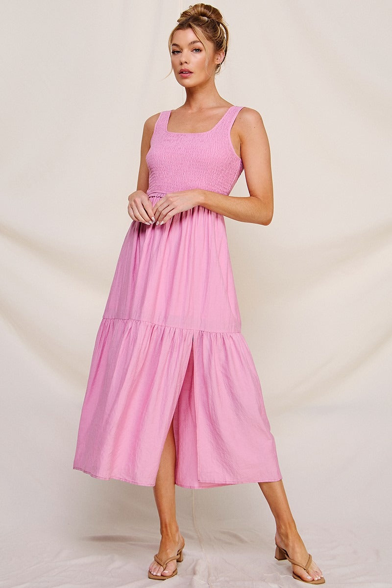Woman wearing a pink dress against a plain background
