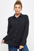 Woman wearing a black button-up shirt and blue jeans on a white background