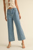 Person wearing light blue jeans on a beige background