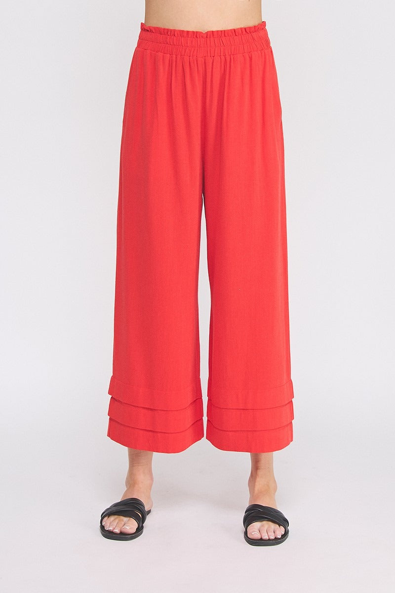 Red wide-leg pants worn by a person on a white background
