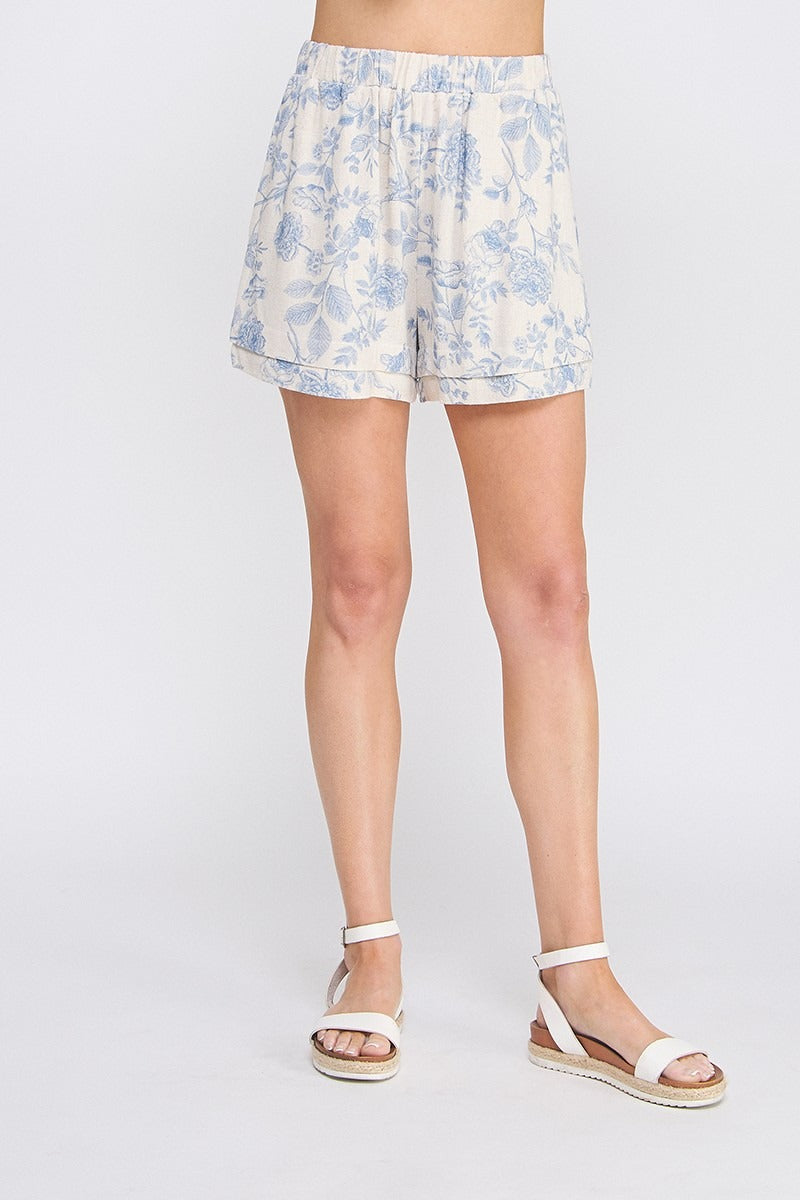 Floral shorts worn by a person on a plain background
