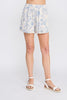 Floral shorts worn by a person on a plain background