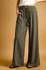 Person wearing olive green wide-leg pants on a beige background
