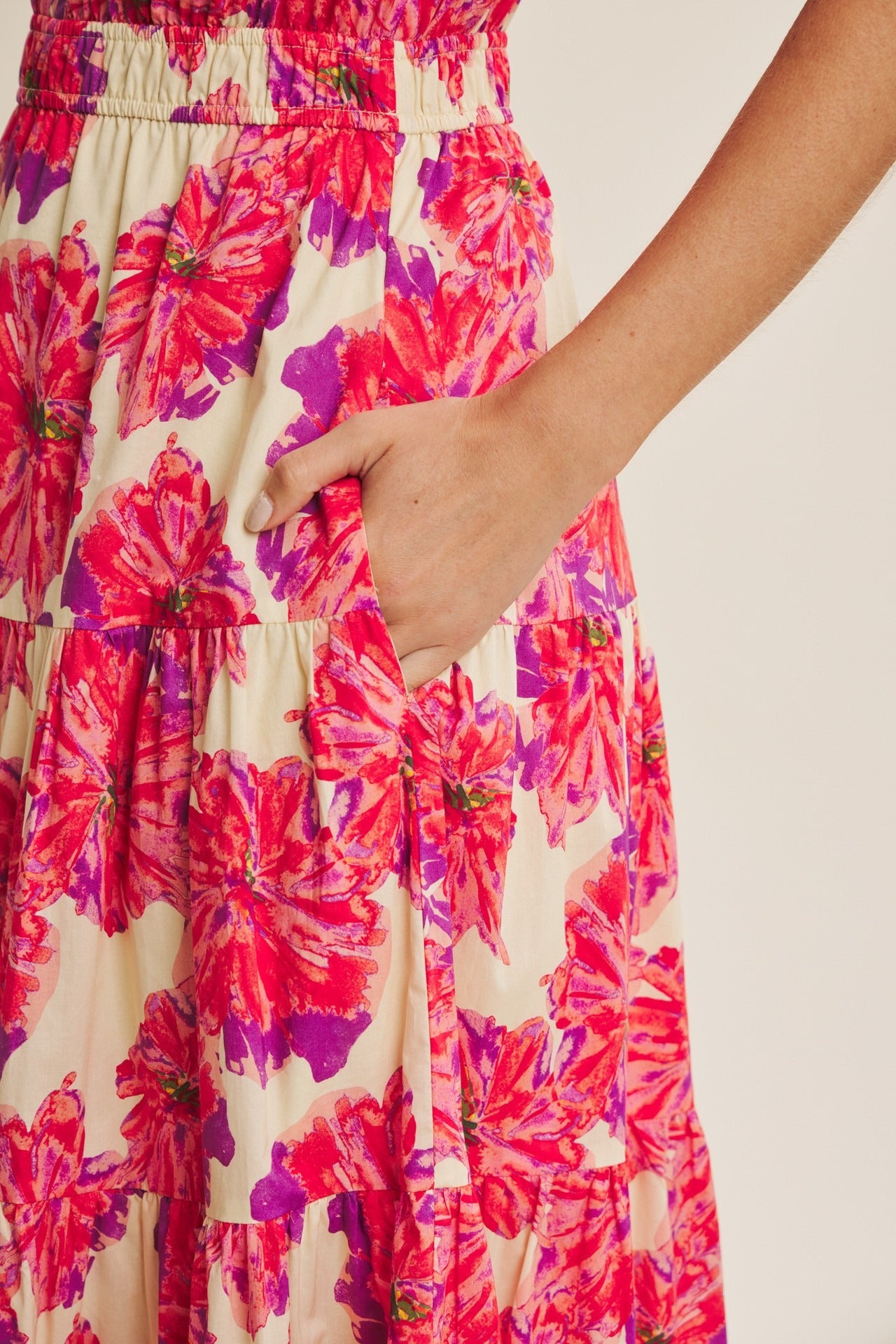 Close-up of a floral dress with pink and purple flowers on a beige background