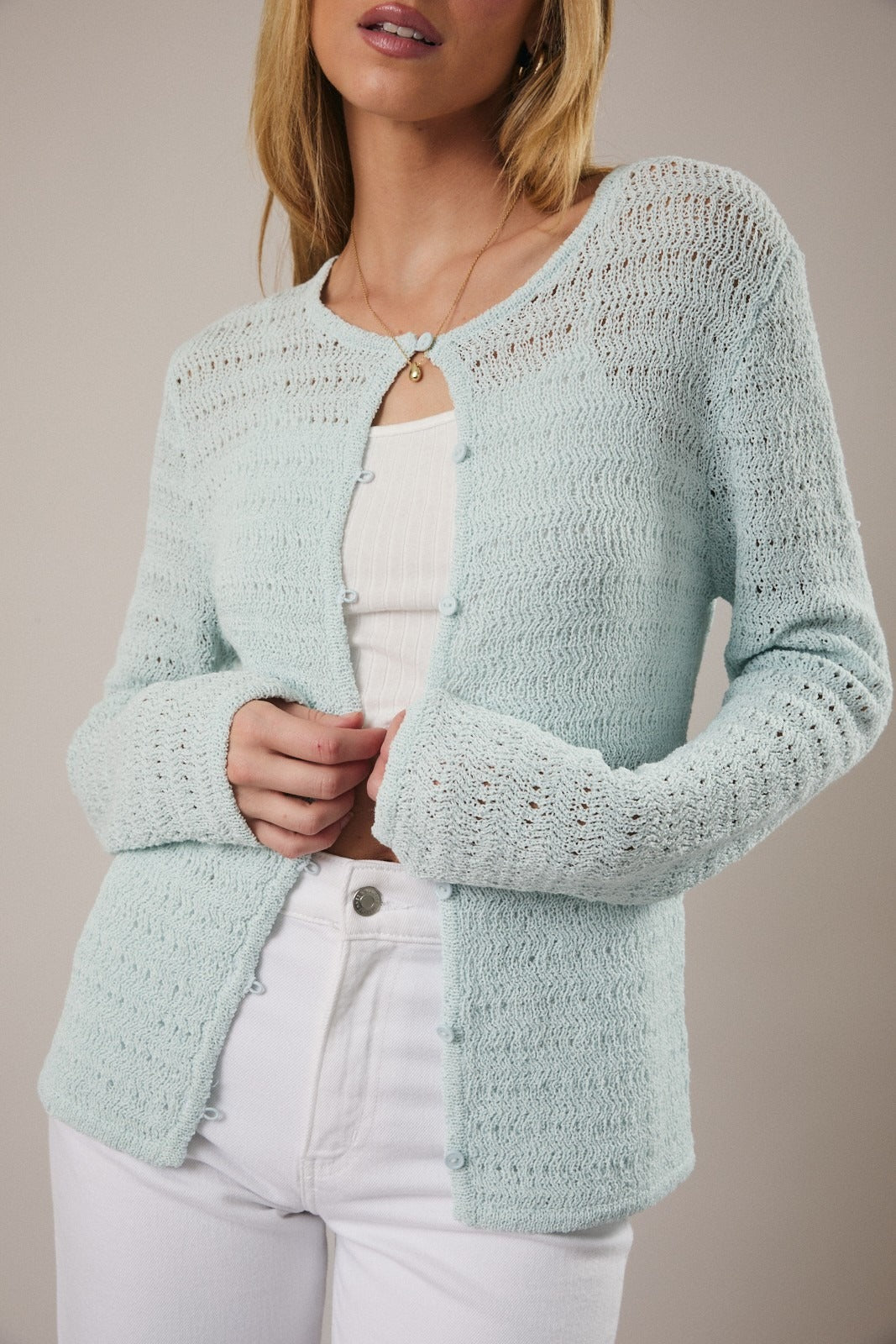 Light blue knitted cardigan worn by a person on a neutral background