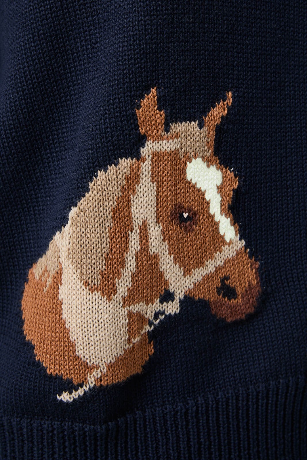 Navy sweater with a brown horse design on a dark background